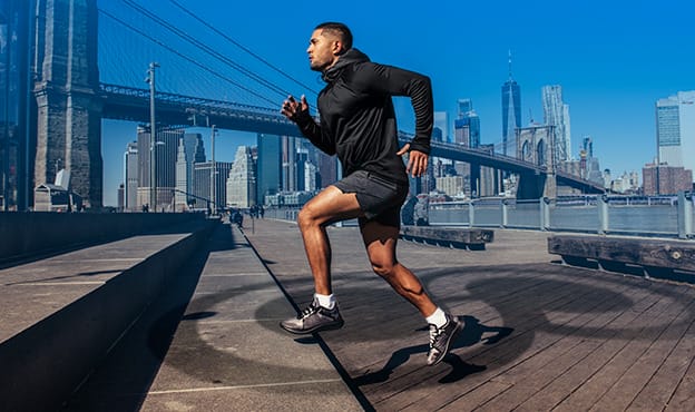 Man running up steps with city in the background